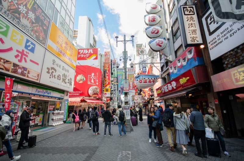 Dotonbori Street During The Day Busy With People And Colorful Shops